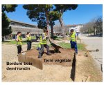 Vignette Image 1 : Cinq élèves metent en place, devant le lycée, un massif "aromates", constitué d'une bordure en bois, en demi rondin sur 40 centimètres de hauteur. de la terre végétale facilite le développement d'espèces telles que le thym, le romarin, la sauge, les lavandes... . Ils sont vétus de gillets jaune et équipés d'outils de jardinage : brouette, pelle, bêche.... 