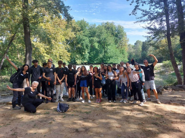 Groupe d'élèves du lycée devant une prairie avec des arbres en arrière plan.