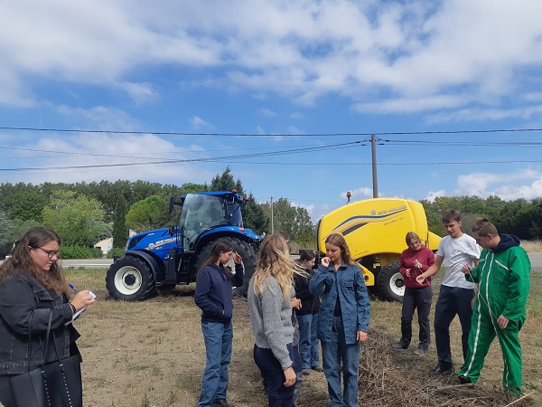 Les élèves du lycée agricole de Castelnaudary sont sur la parcelle de chanvre. A l'arrière plan un tracteur équipé pour la moisson.