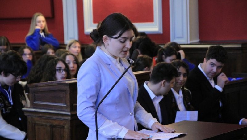 En premier plan, une élève du lycée devant un micro pour les Plaidoiries lors de la session qui s'est déroulée en Roumanie